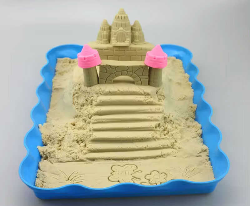 sand castle in blue tray with pink towers and steps